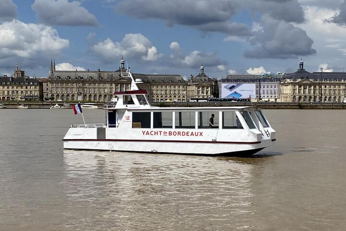 a white boat on the water in front of a city