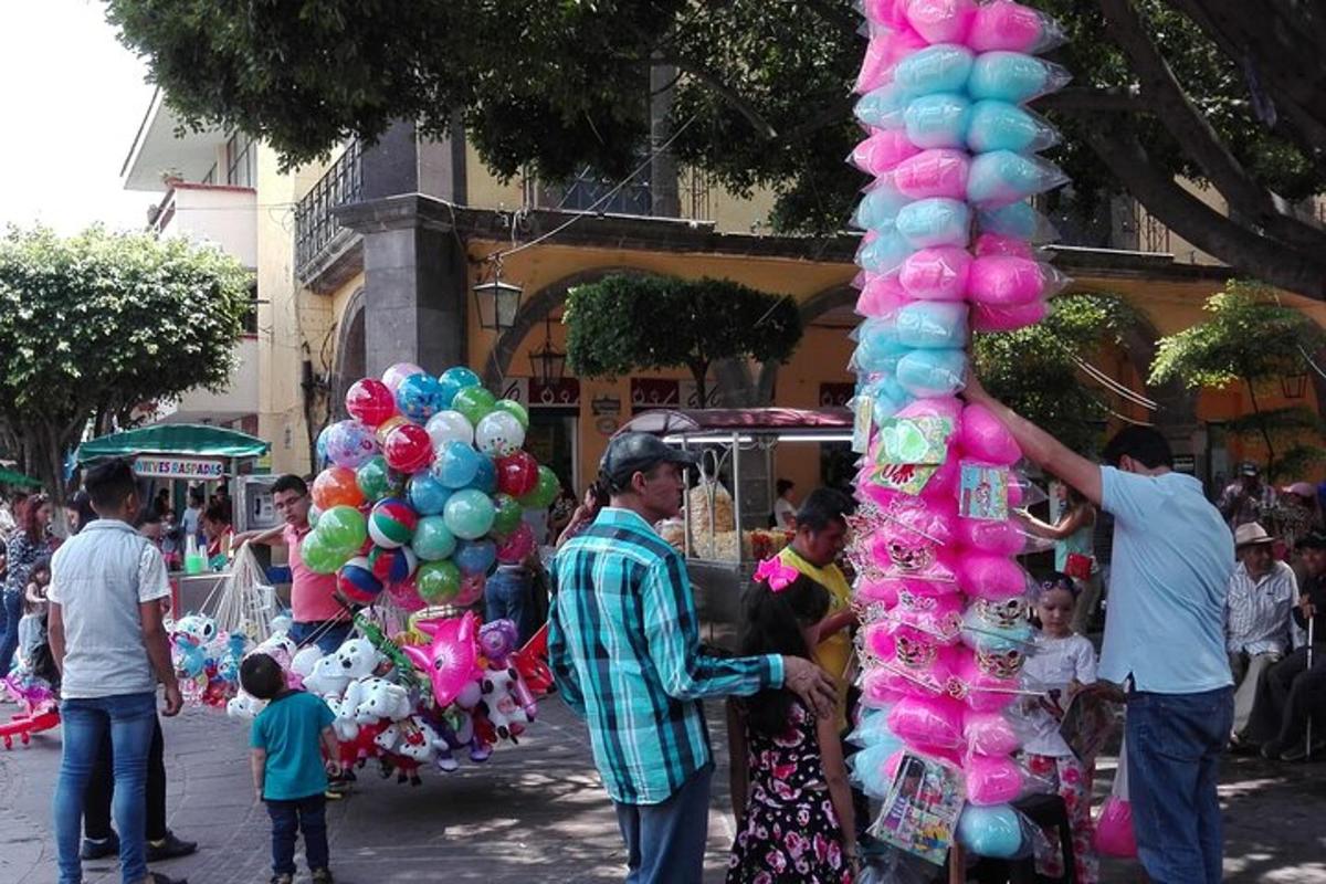Un hombre está de pie junto a un montón de globos.