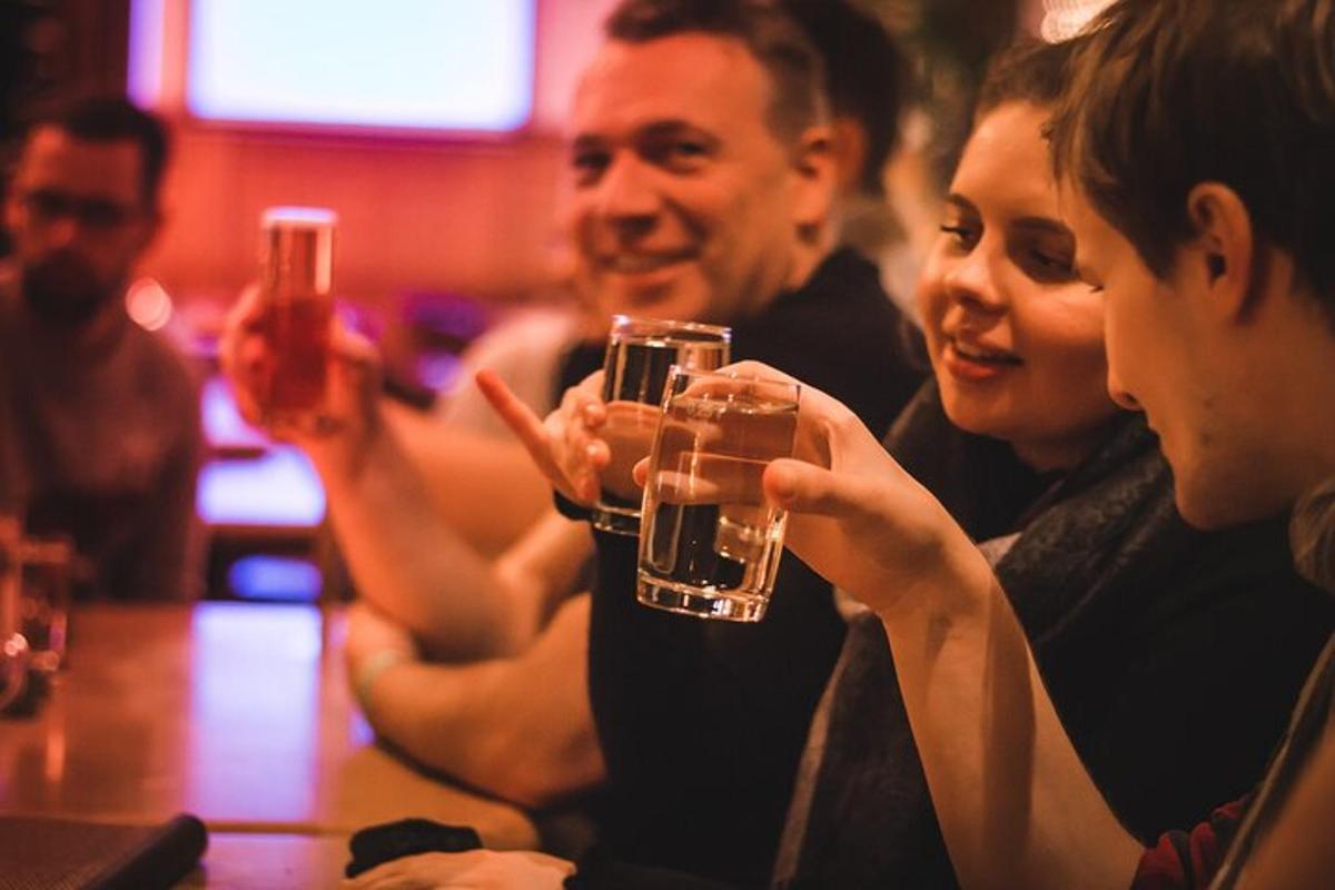 een groep mensen die aan een tafel zitten en glazen omhoog houden