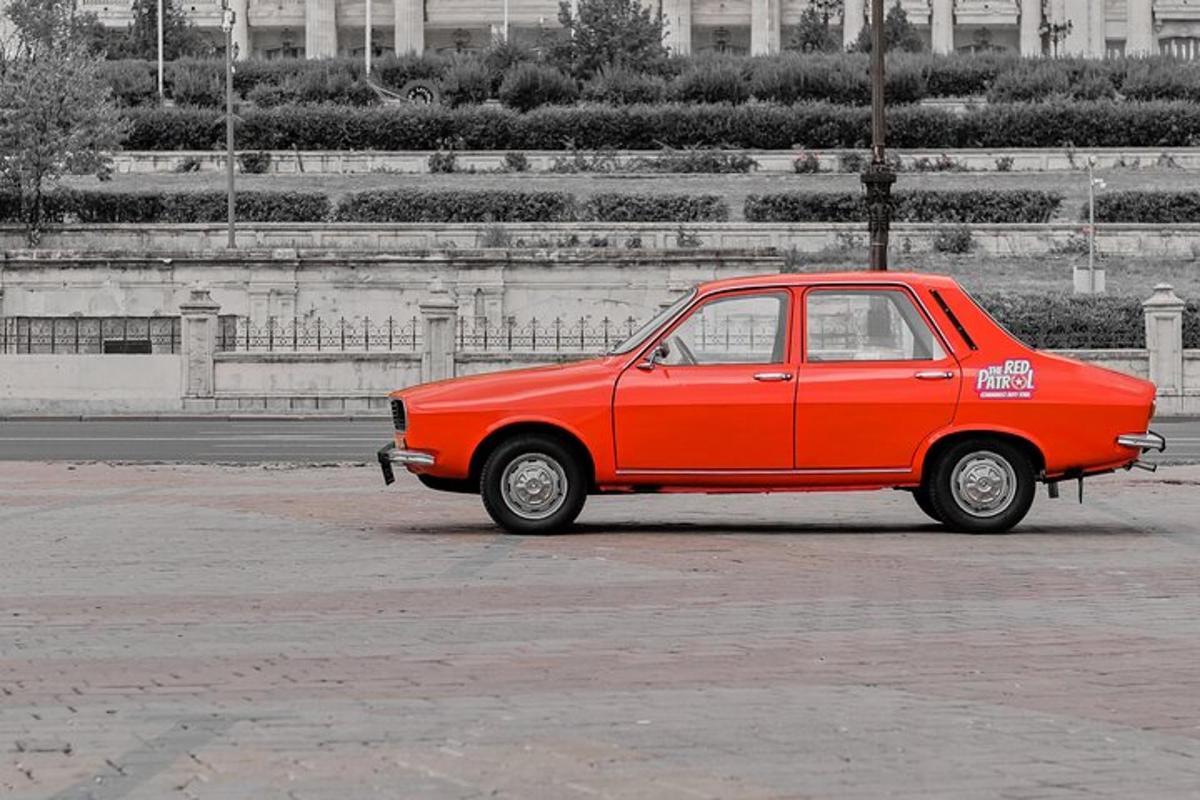 a small red car parked in a parking lot