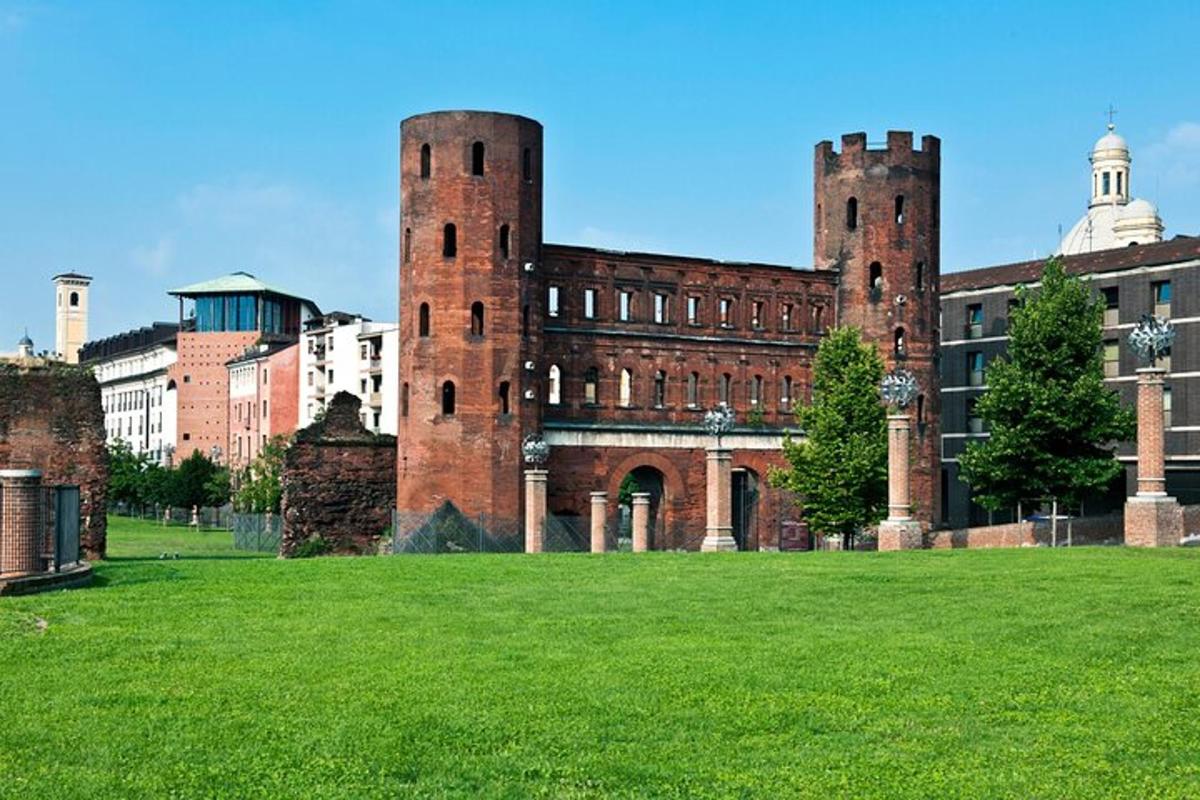 a large brick building with two towers on a grass field