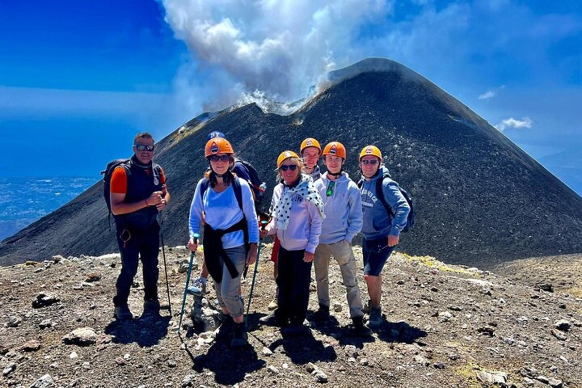 Un grupo de personas de pie frente a un volcán.