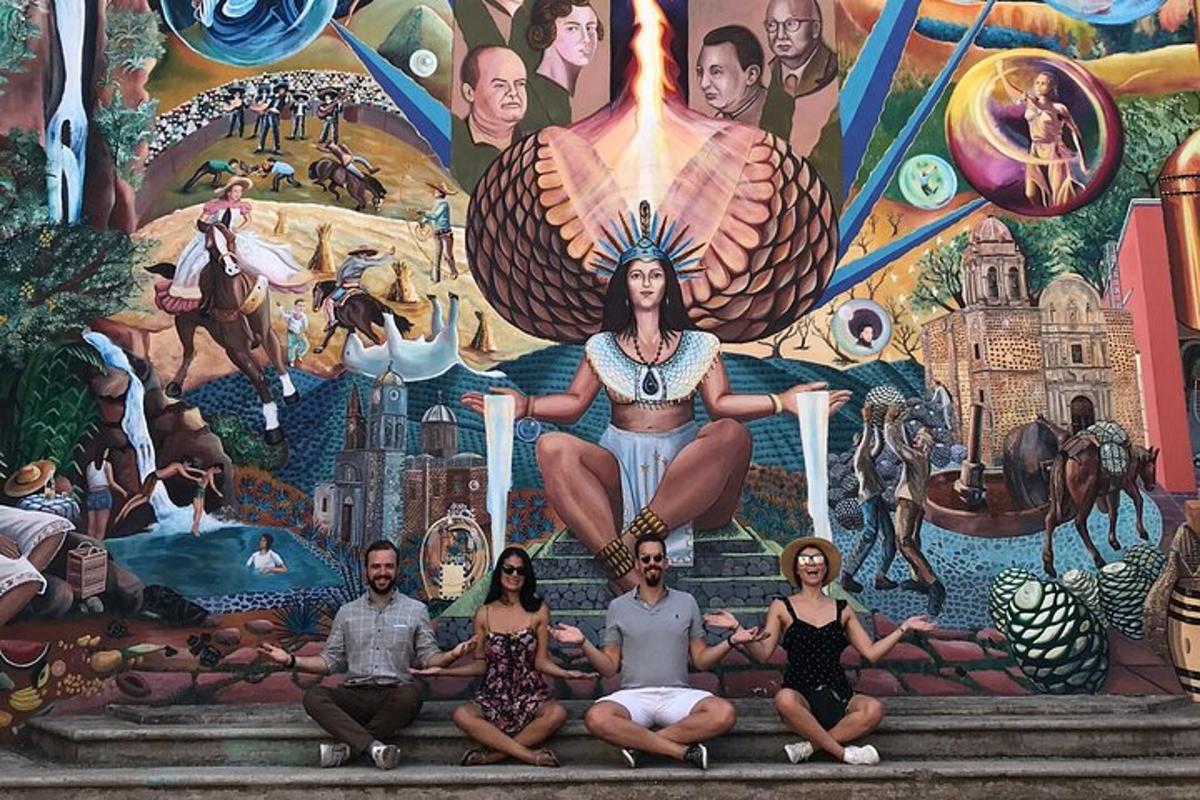 un gruppo di persone sedute davanti a un murale