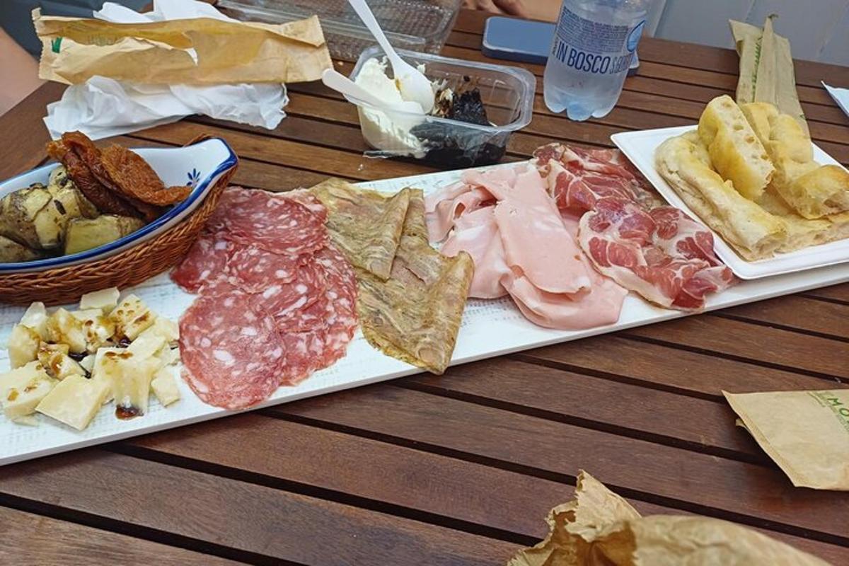 een tafel met twee borden met verschillende soorten vlees en kaas