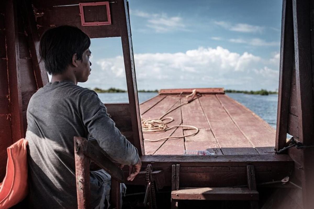 um homem sentado na parte de trás de um barco