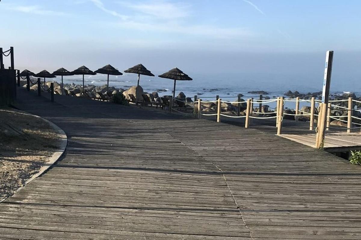 una passerella di legno con ombrelloni sulla spiaggia