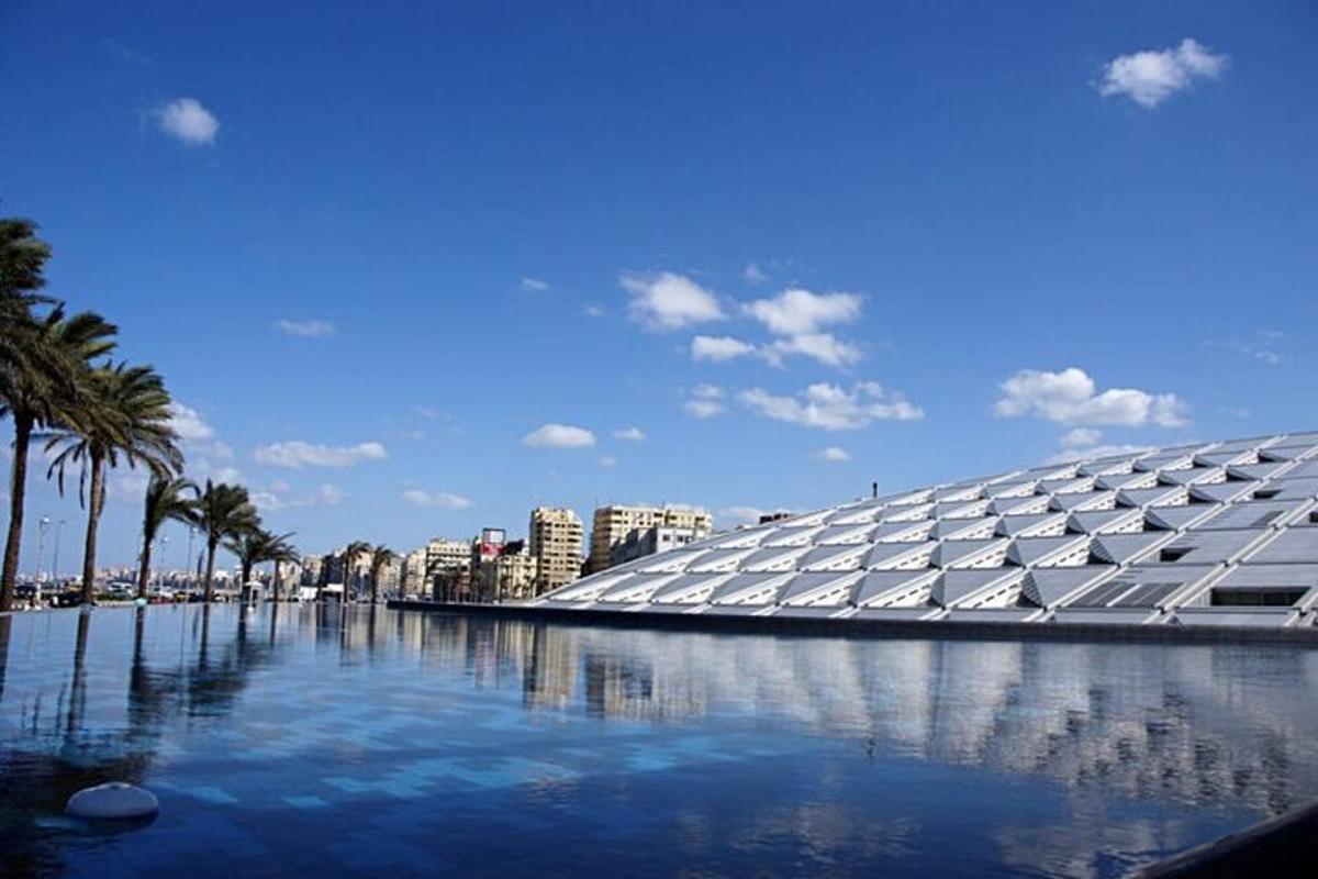 un grande edificio con una piscina d'acqua e palme