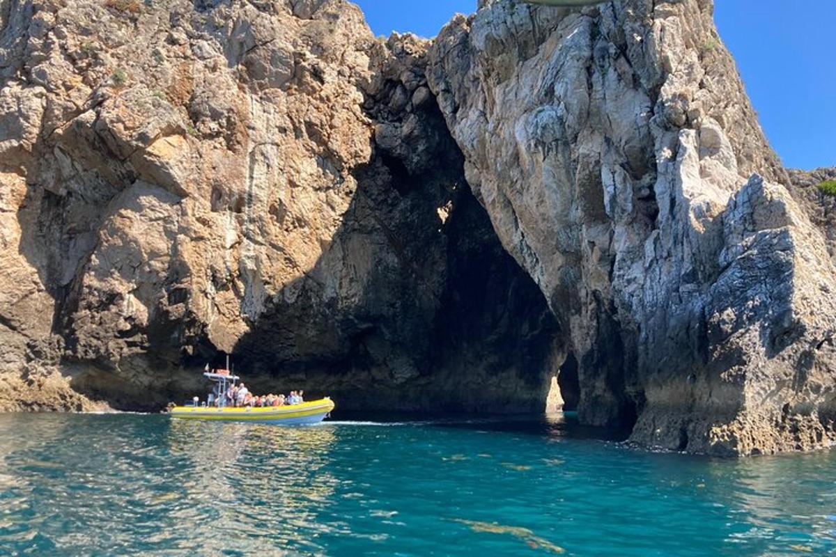 a group of people on a boat in front of a cave