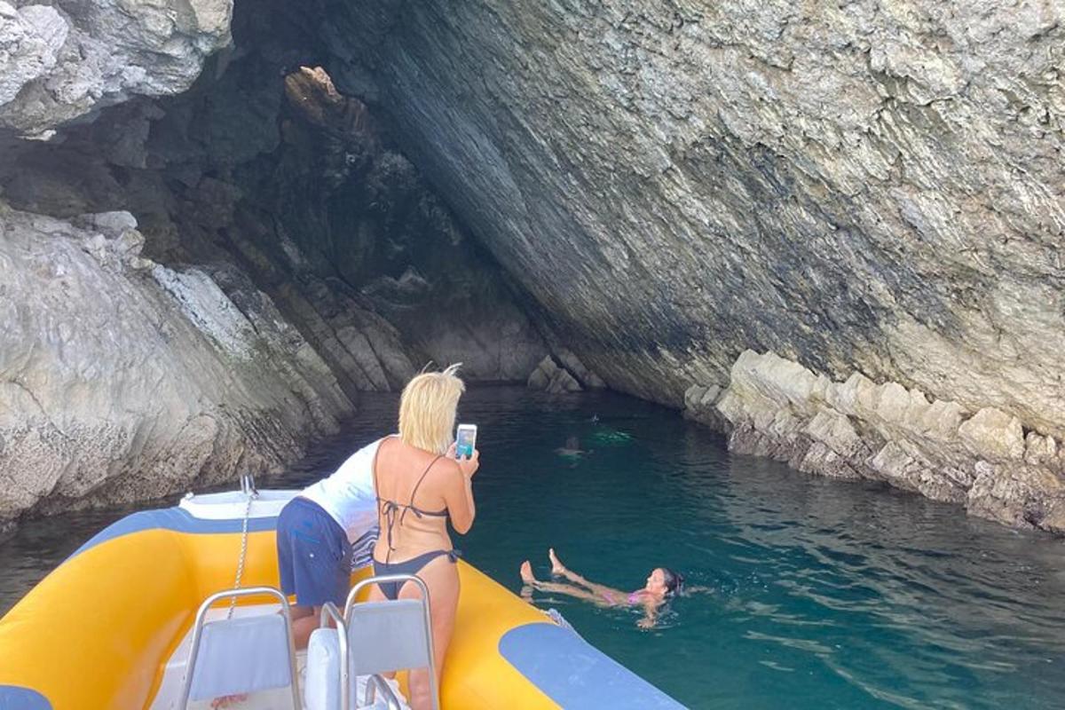 a woman taking a picture of people in the water on a boat