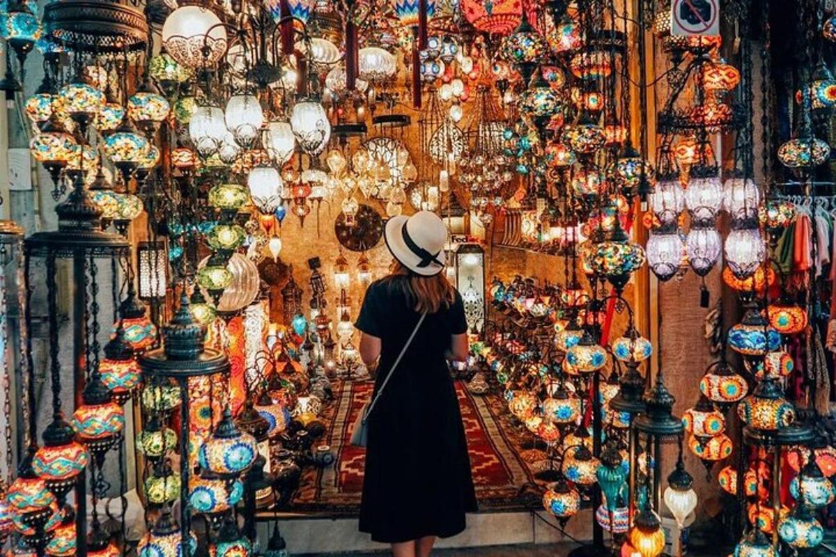 seorang wanita berdiri di hadapan sebuah kedai yang dipenuhi lampu