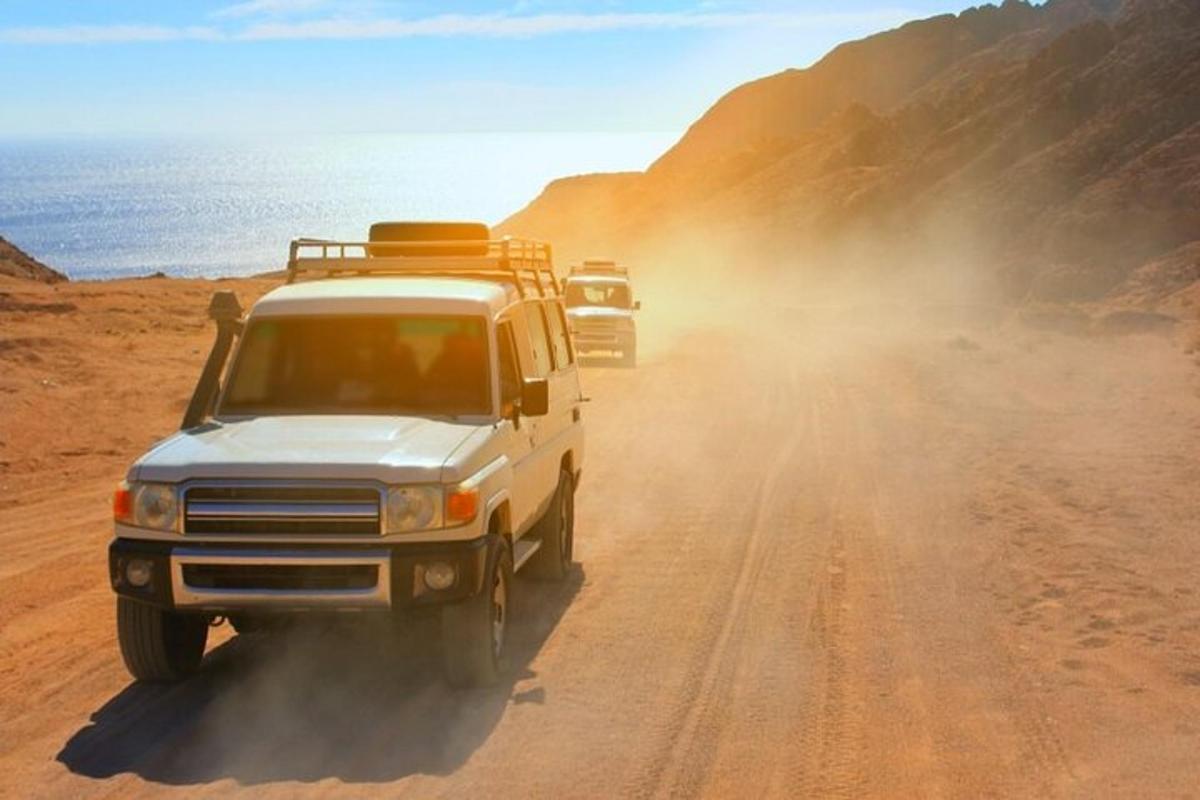 a group of vehicles driving down a dirt road