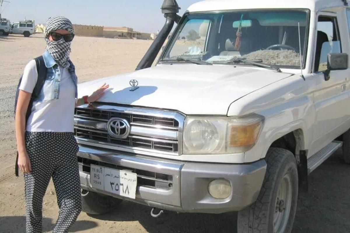 a woman standing next to a truck in the desert