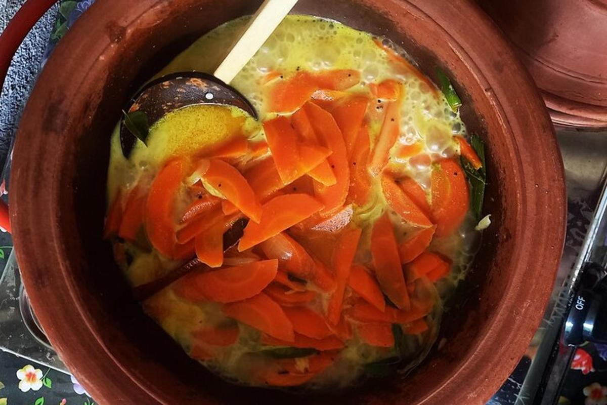 kulhollinen keittoa porkkanoiden ja lusikan kera