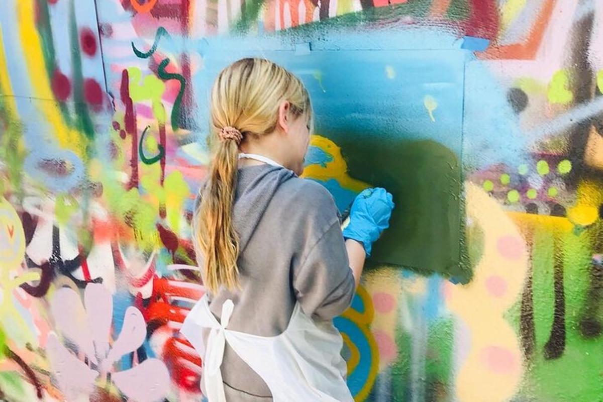 uma jovem pintando uma parede com grafite