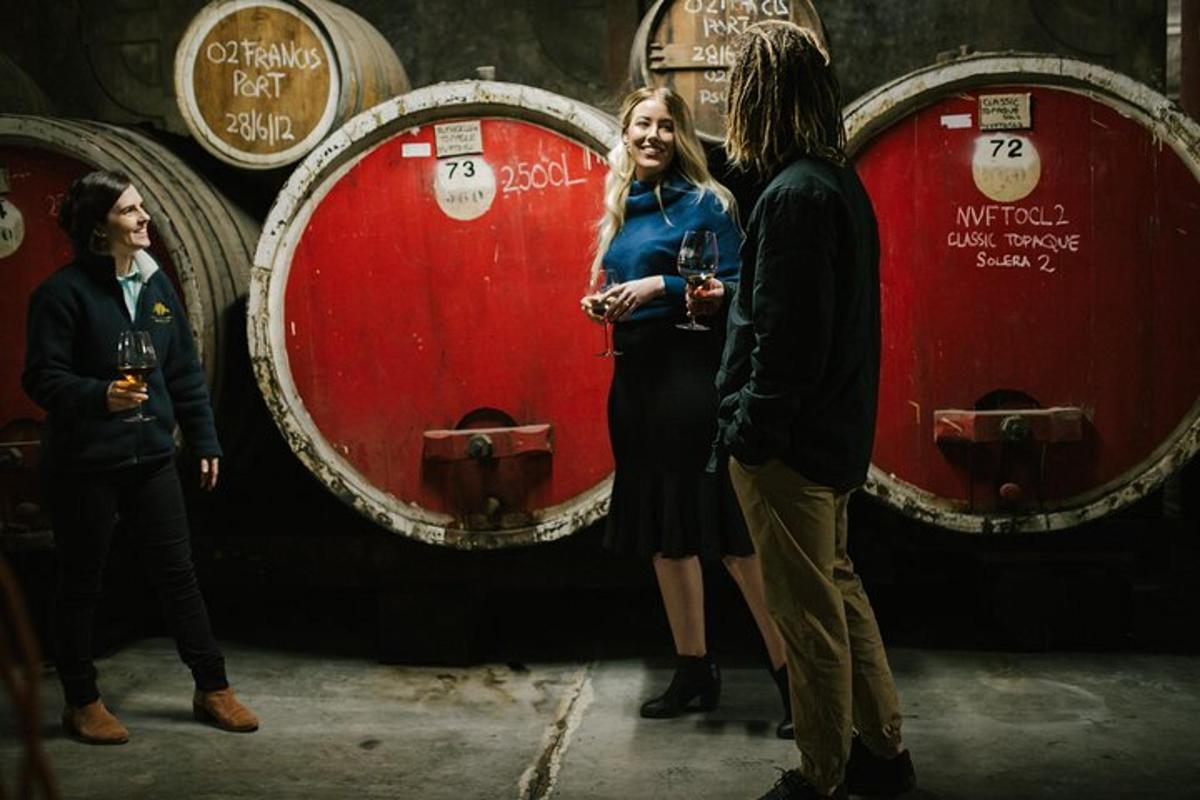 a woman standing in front of three wine barrels