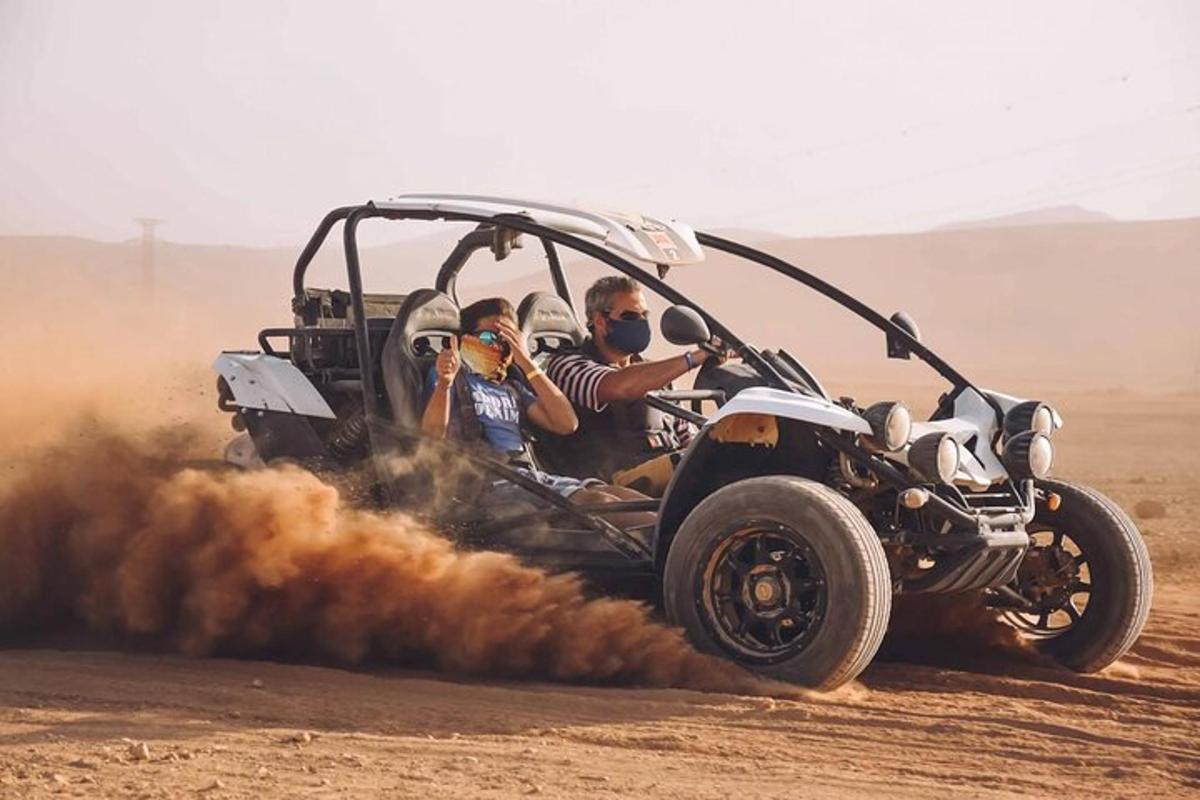 duas pessoas andando de jipe no deserto
