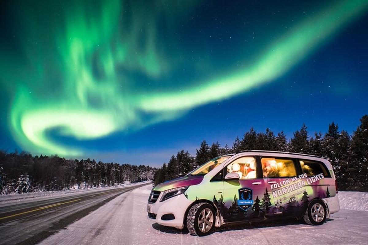a car parked on a road under the northern lights