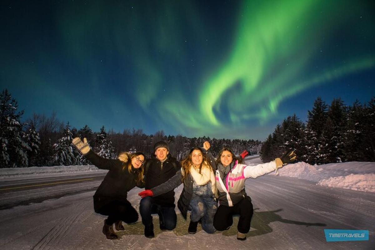 a group of people posing for a picture under the northern lights