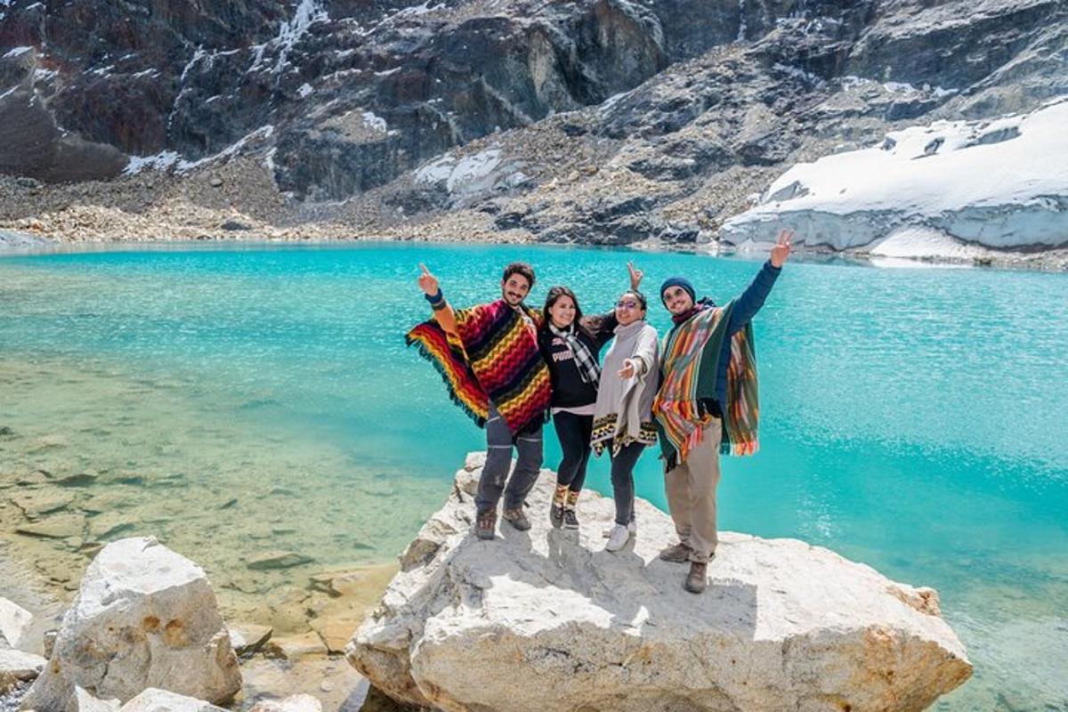 a group of people standing on a rock in front of a lake