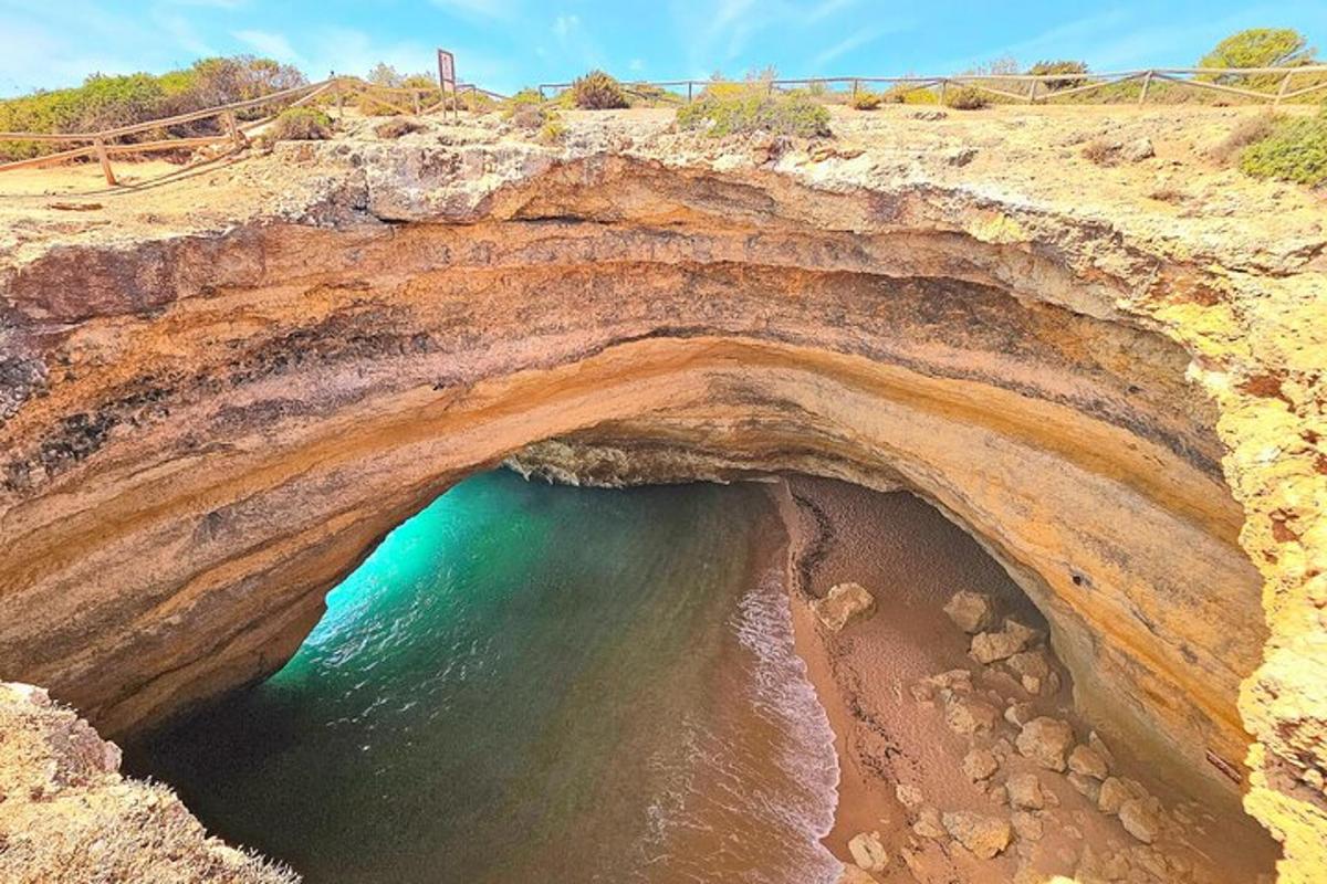uma grande caverna em uma praia com o oceano