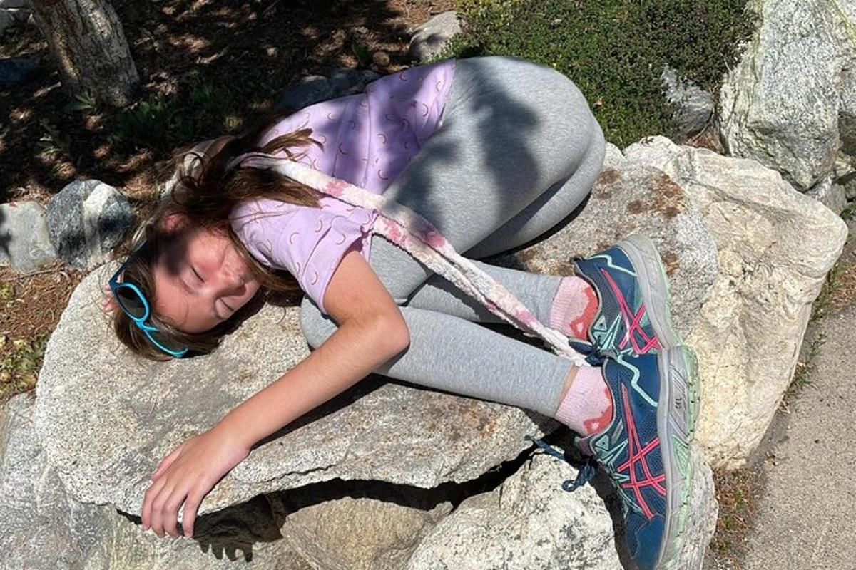 ein junges Mädchen liegt auf einem Felsen