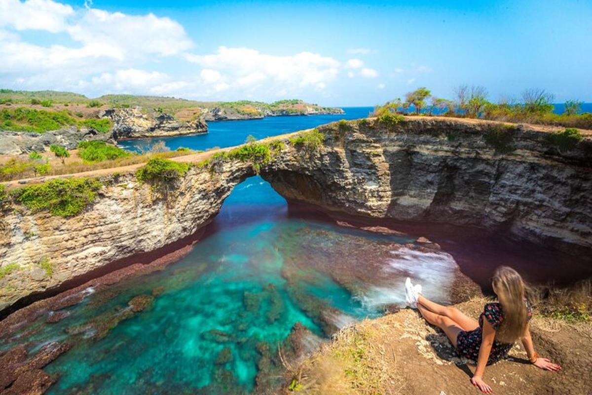 a woman sitting on a rock in a body of water