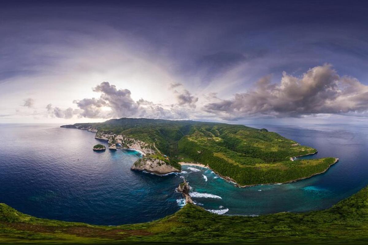 an island in the ocean under a cloudy sky