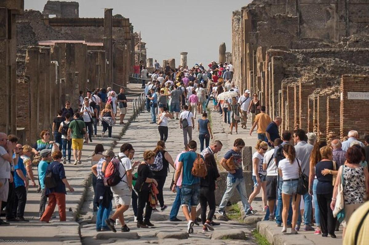 velká skupina lidí procházejících se kolem ruin lázní