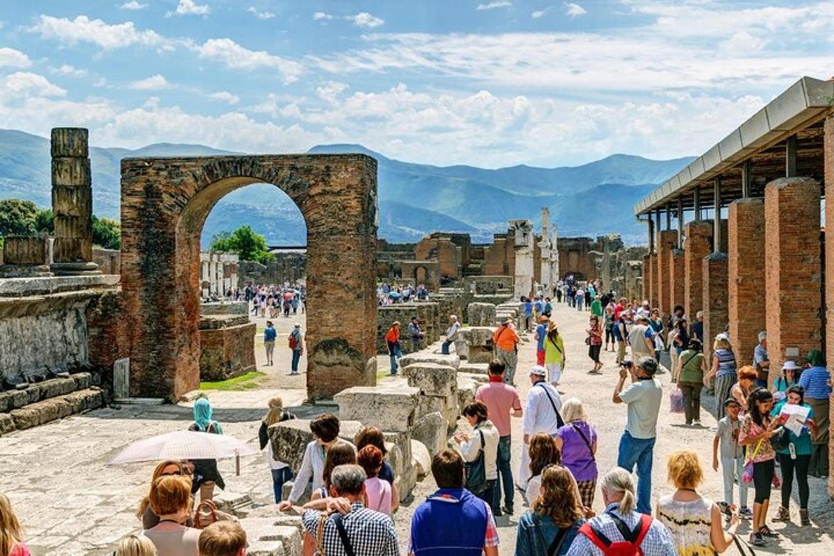Una multitud de personas caminando alrededor de las ruinas.