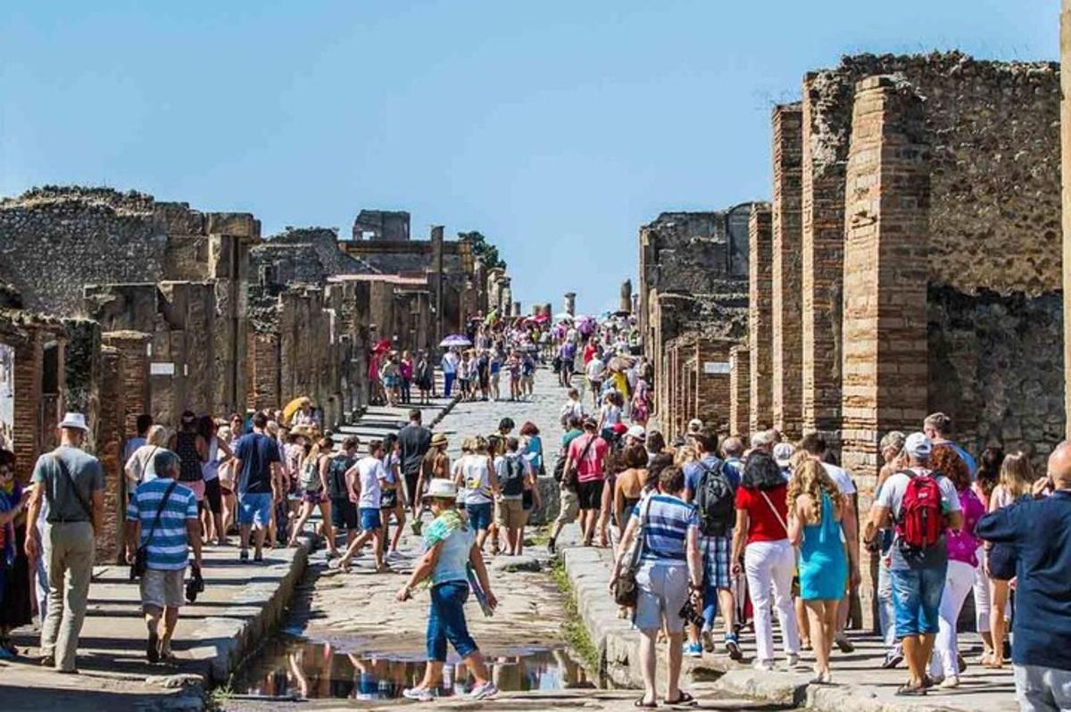 velký dav lidí procházejících se kolem ruin