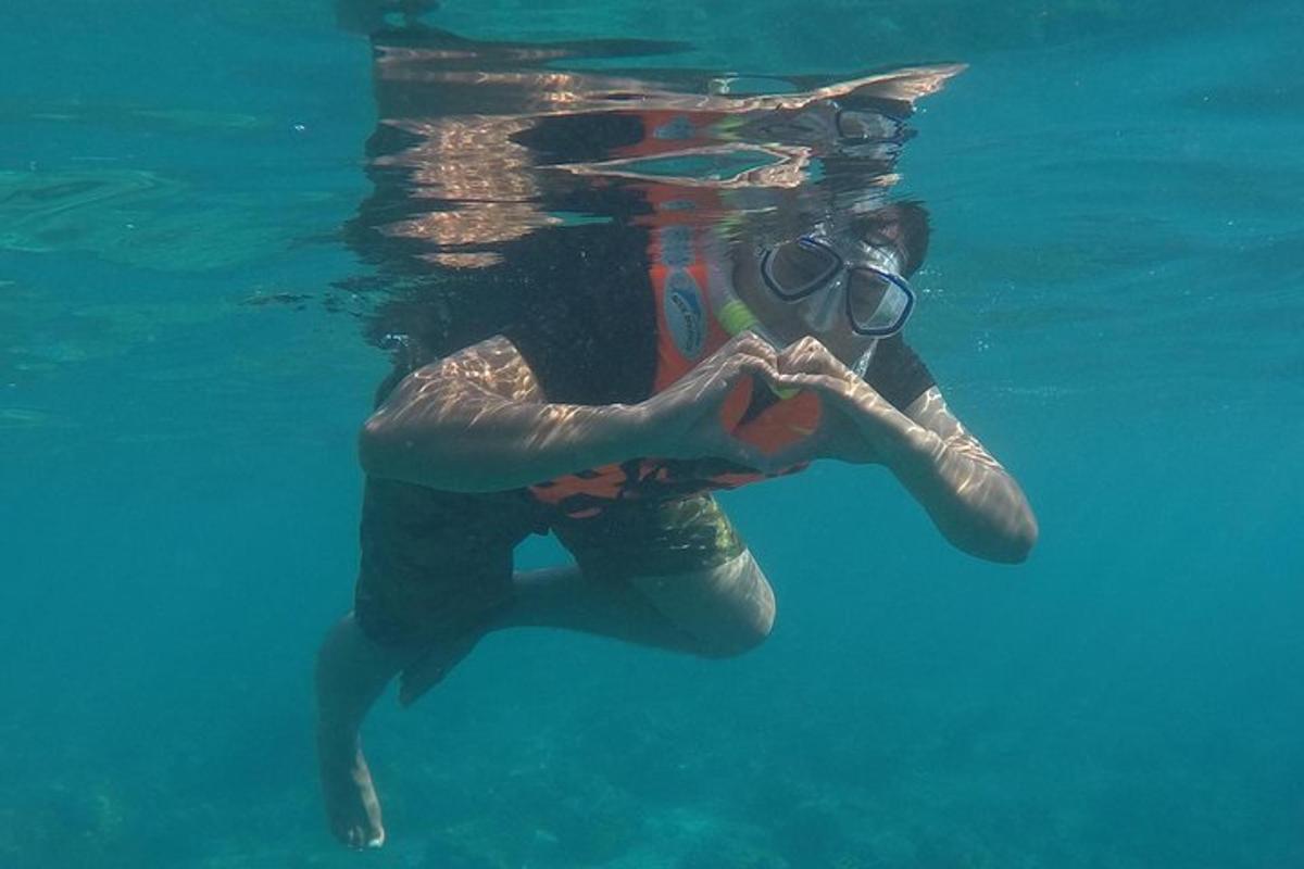 a woman in the water making a heart sign