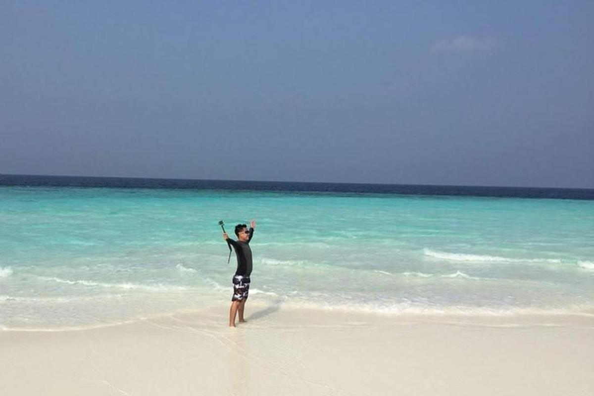 a man standing on a beach with a kite