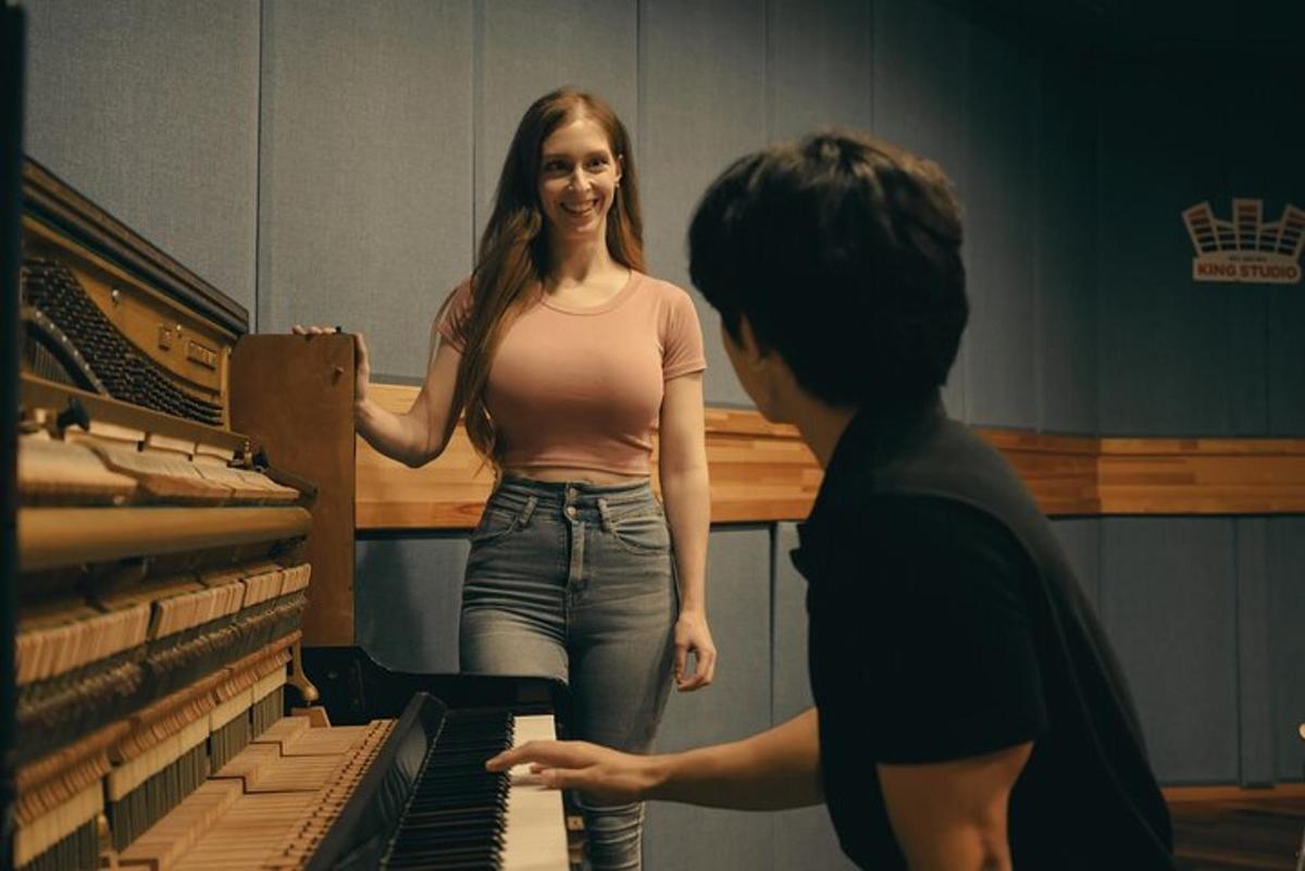 a woman is standing next to a piano
