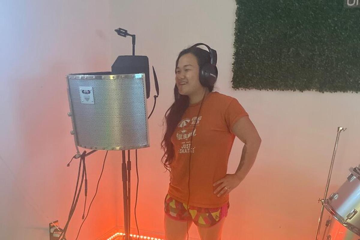 a woman wearing headphones standing in front of a microphone