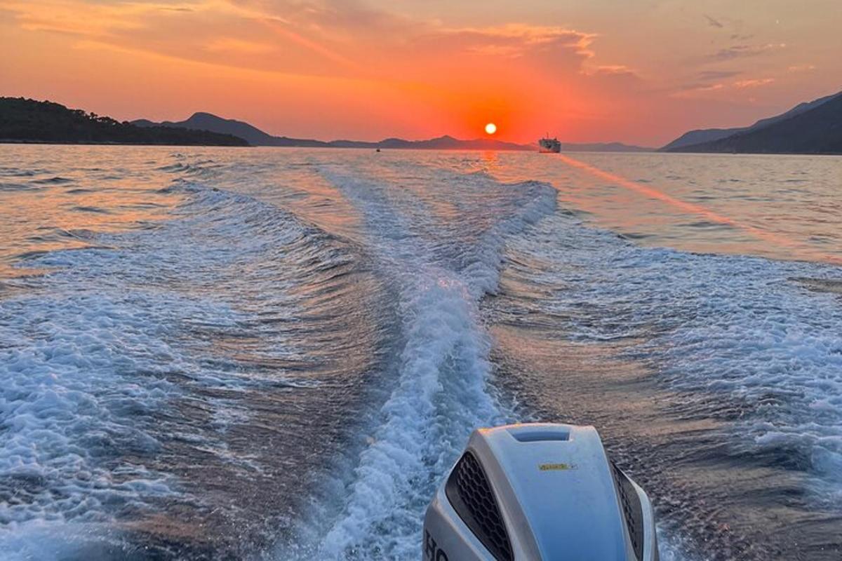 a boat in the water with the sunset in the background