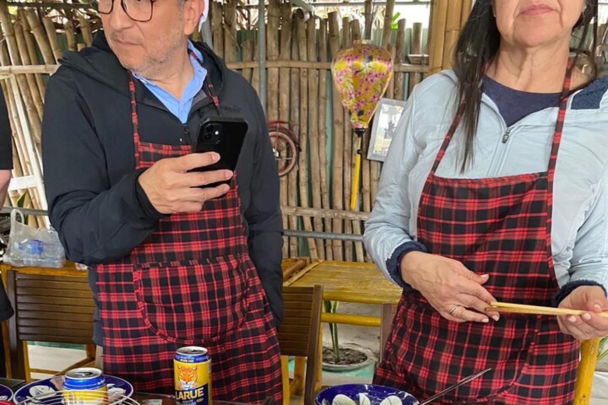un uomo e una donna in grembiule che guardano un cellulare