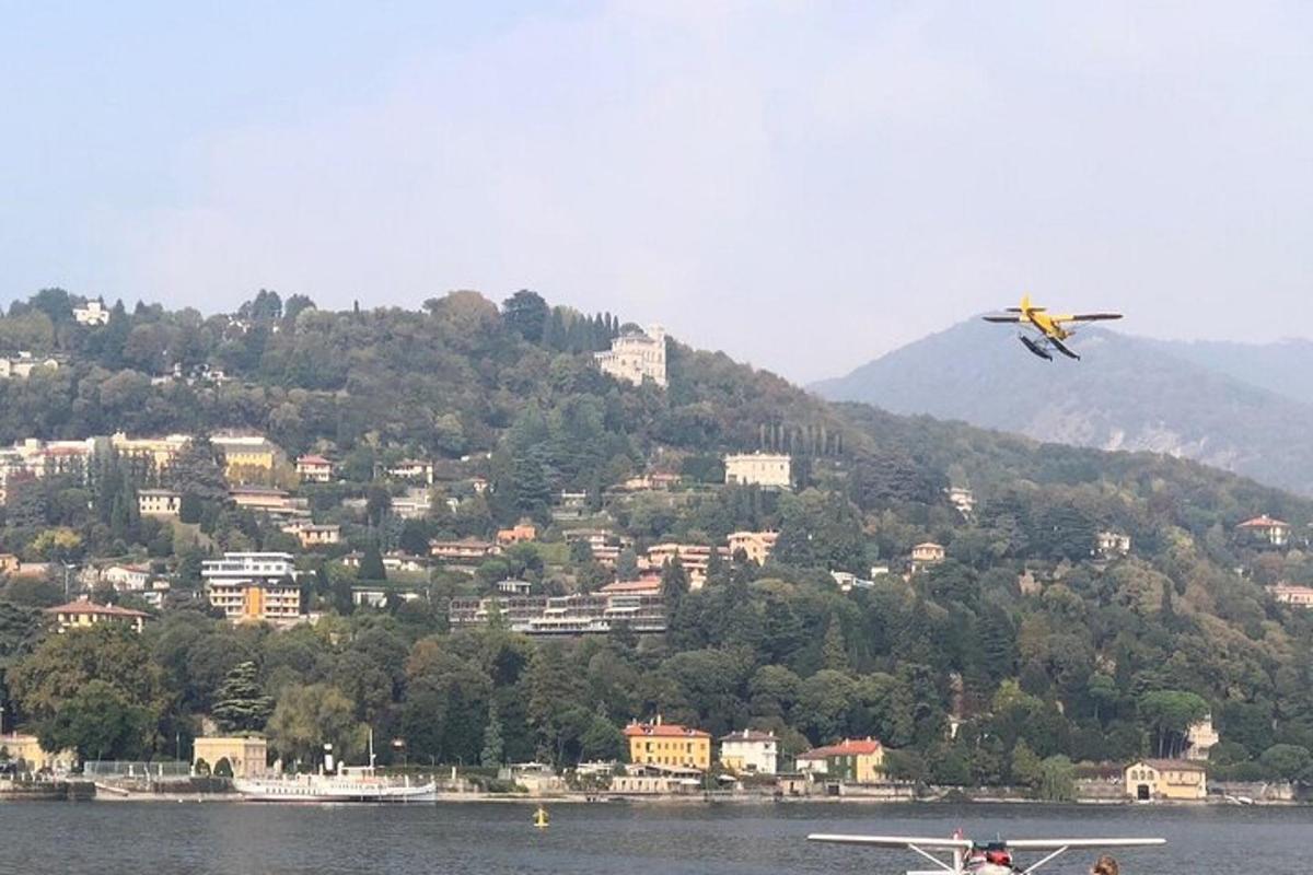 un aereo che vola sopra uno specchio d'acqua con una montagna