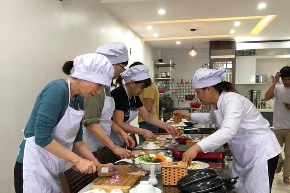 un grup de persones a la cuina preparant menjar