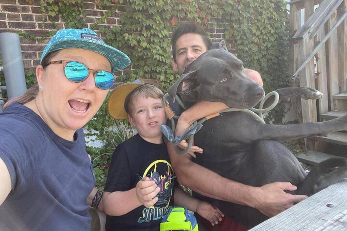 a group of people standing next to a dog