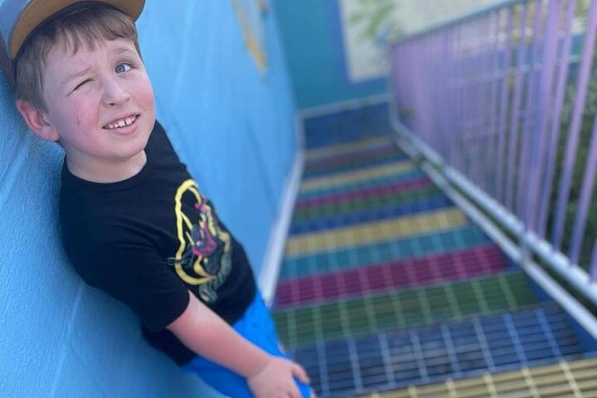 a young boy is sliding down a slide