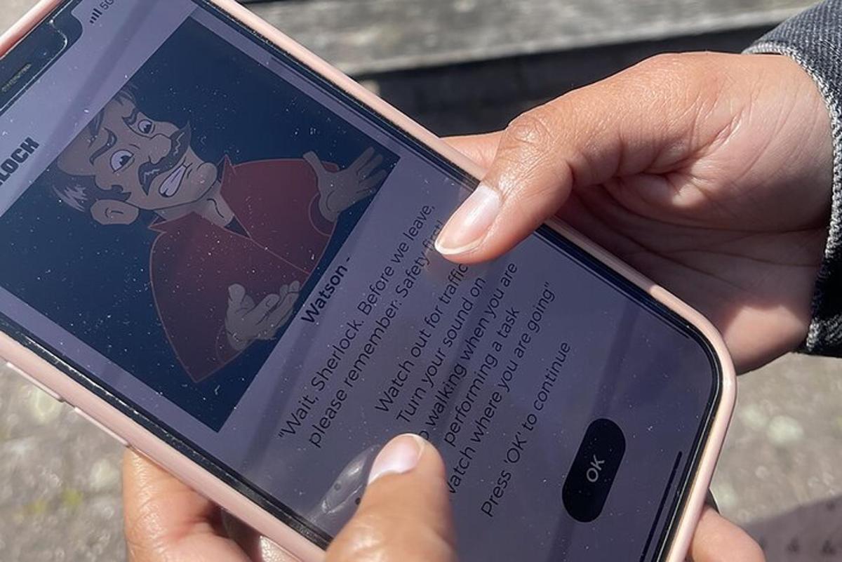 inimene, kes hoiab käes mobiiltelefoni, mille ekraanil on koomiks