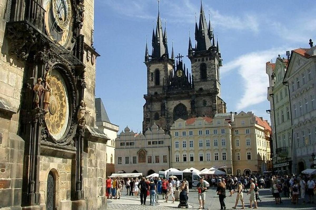 skupina lidí procházejících se městem se dvěma věžemi