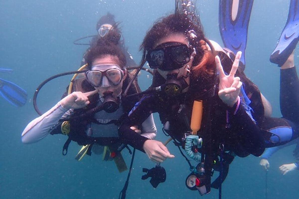 sekelompok orang di dalam air membuat tanda perdamaian