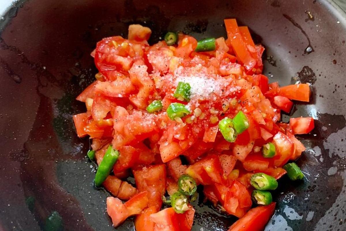 una ciotola di cibo con pomodori e cipolle verdi