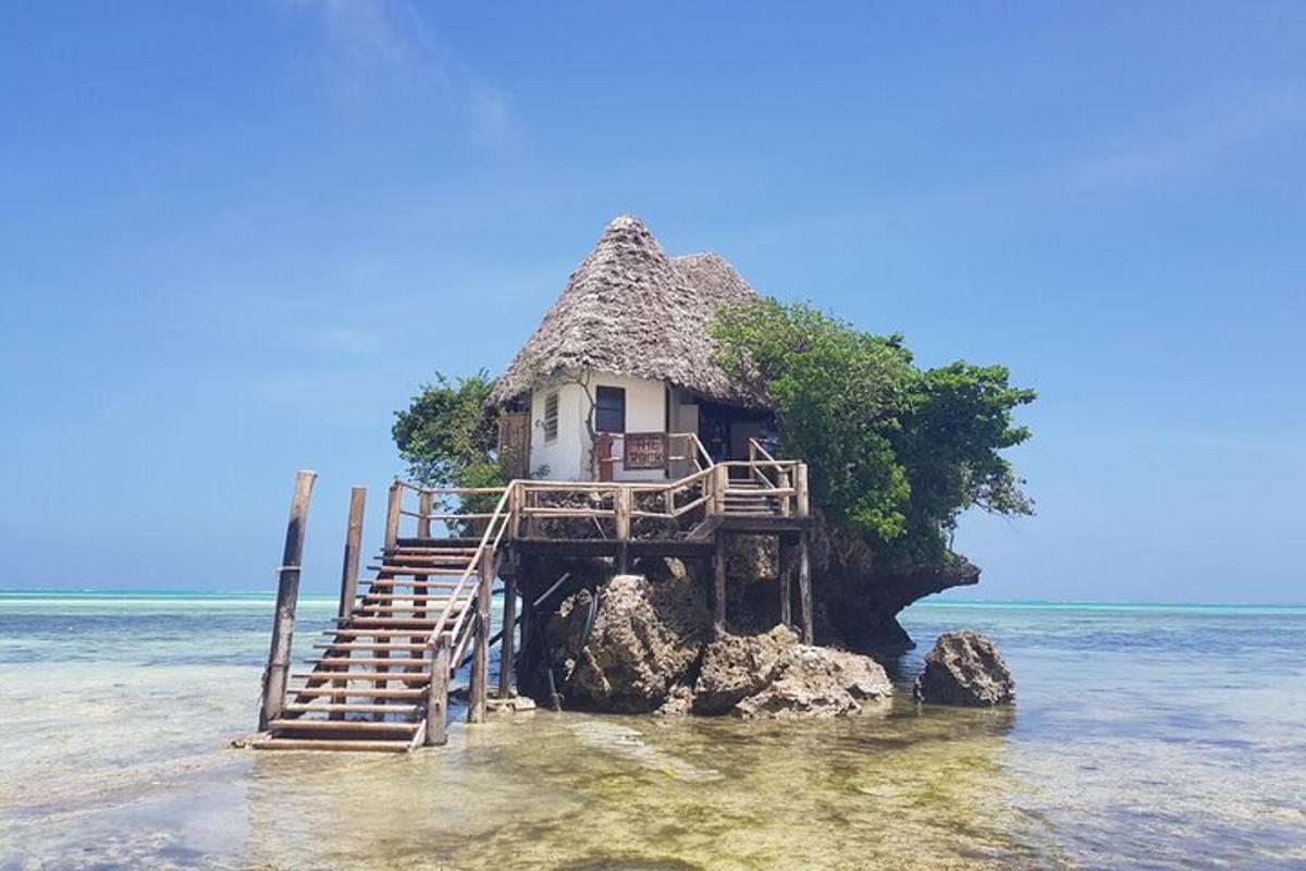 Una pequeña casa sobre una roca en el océano.