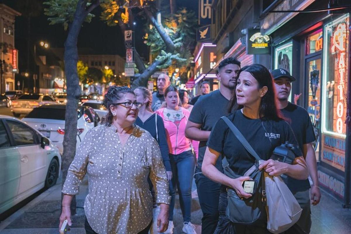 un gruppo di persone che camminano lungo una strada cittadina