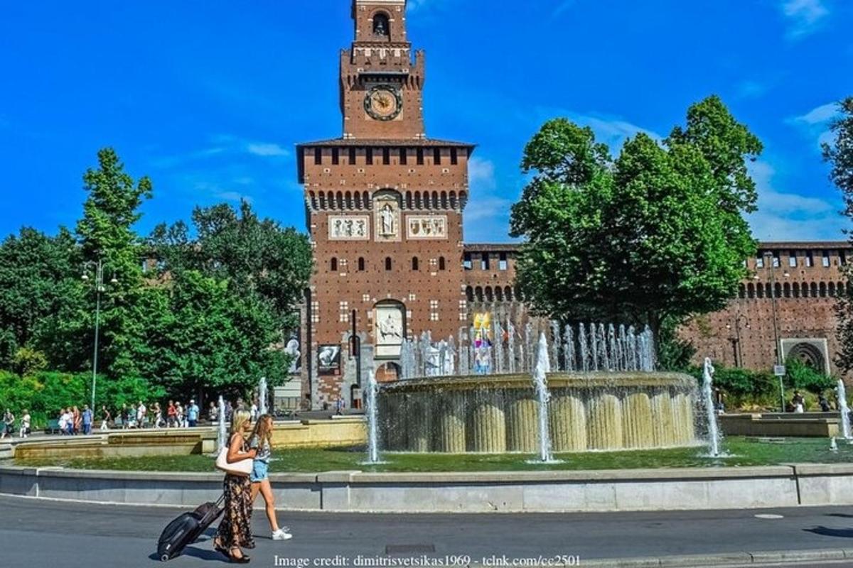 due persone che camminano davanti a un edificio con una torre dell'orologio