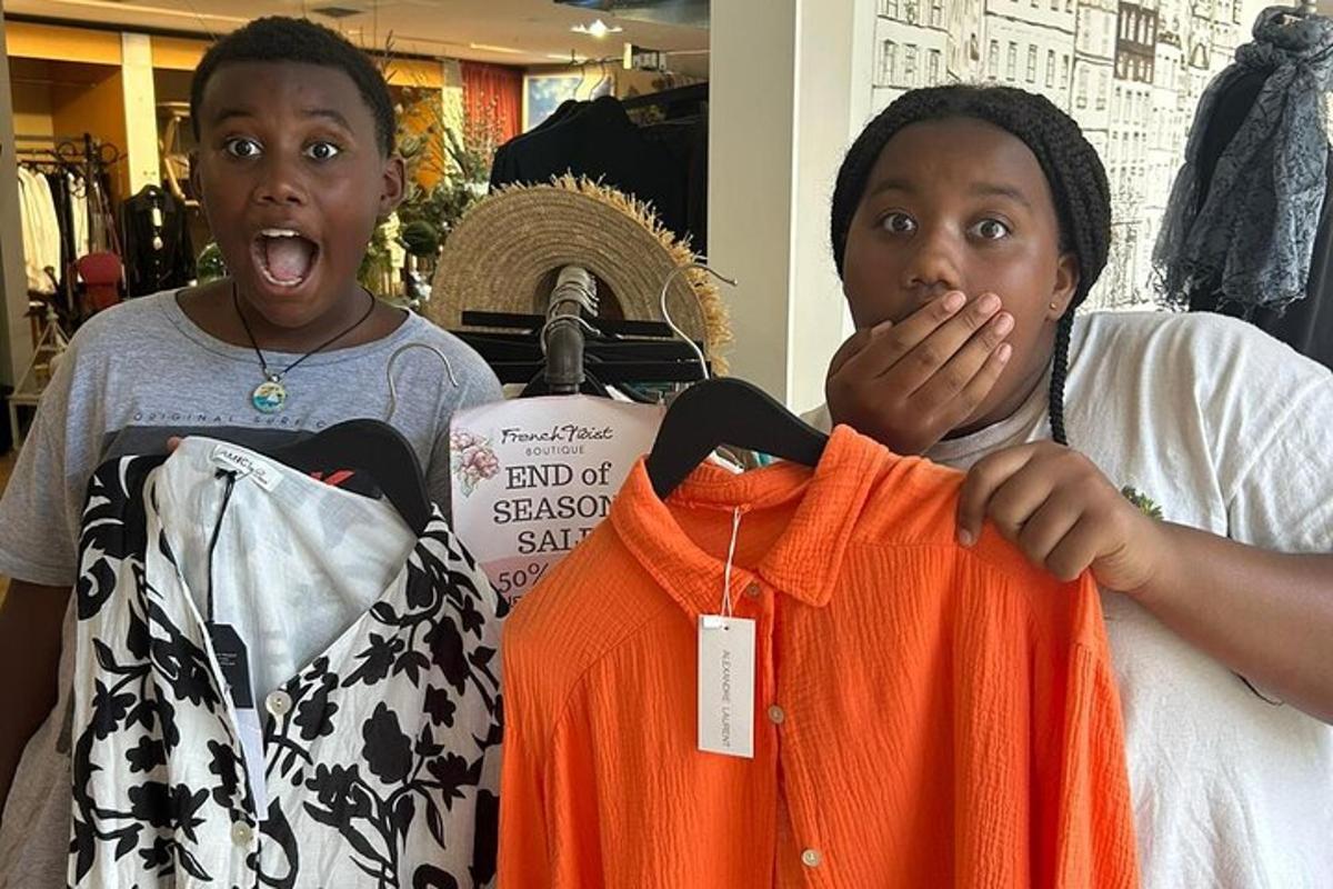 two women are looking at shirts in a store