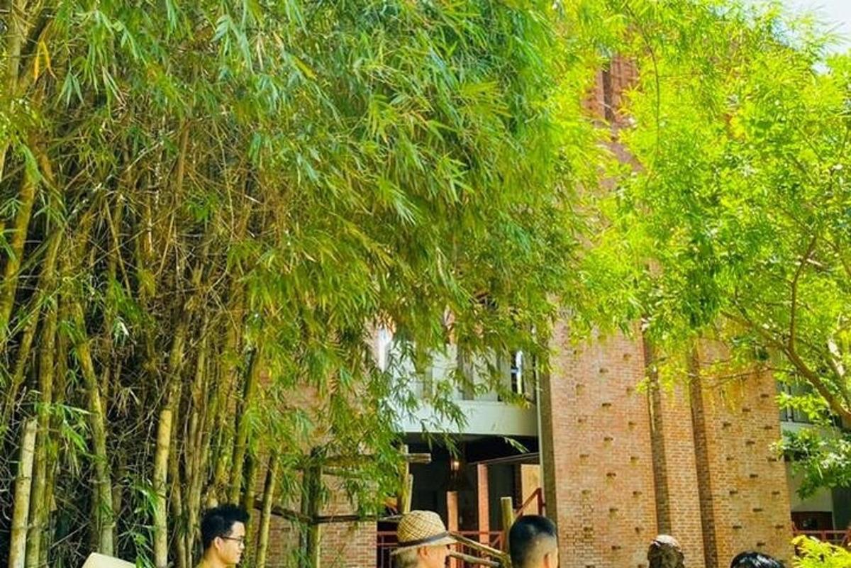 مجموعة من الأشخاص يقفون تحت الأشجار أمام مبنى