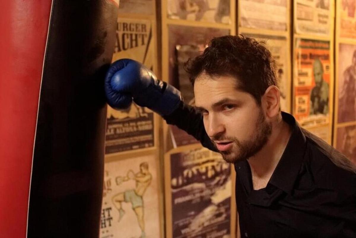 un uomo con un guantone da boxe sul viso